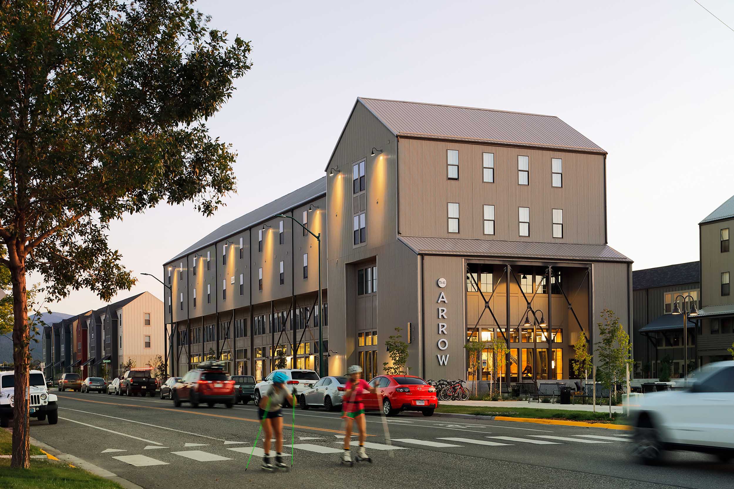 People skating by The Arrow apartment buildings