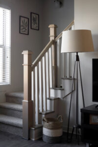 Stairway leading upstairs with lamp and basket beside