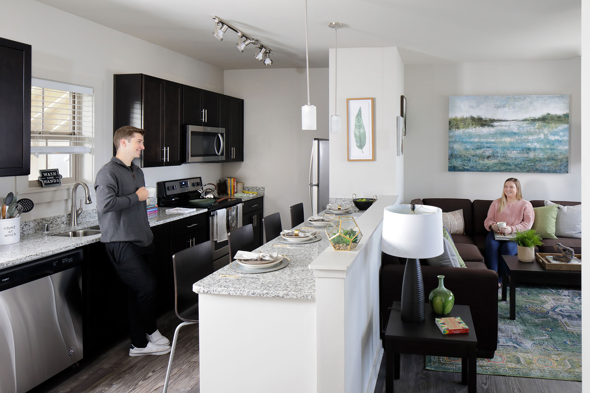 Two residents in apartment living room and kitchen