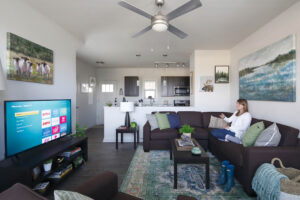 Woman watching TV from couch in apartment living room